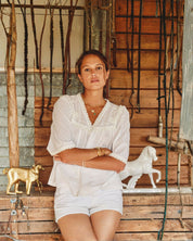 Model wearing white lace cotton blouse by Mabe Apparel in summer.