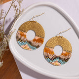 Close-up of Mayana Designs Earth fringe earrings, ombre Miyuki beads and hammered brass arch