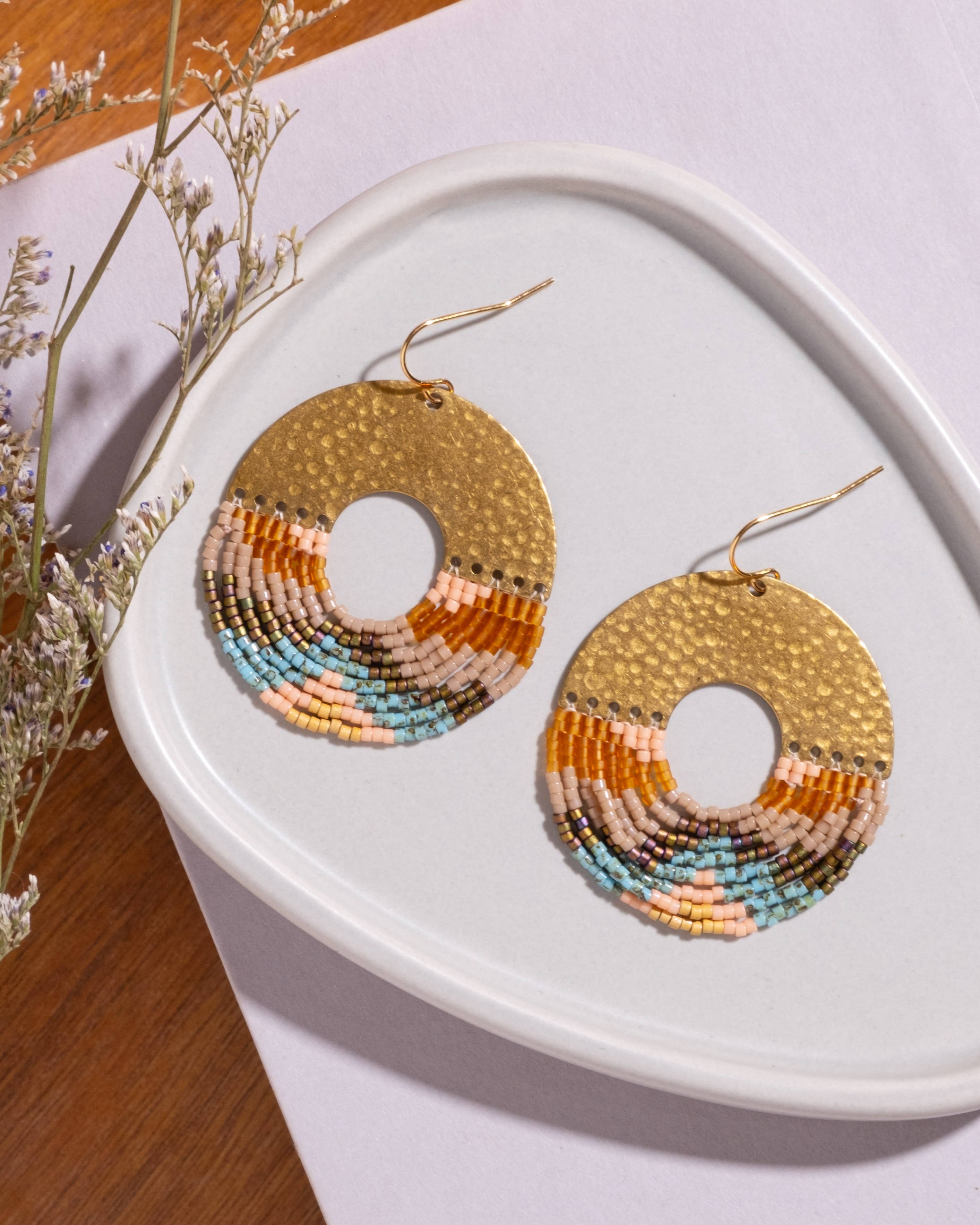 Close-up of Mayana Designs Earth fringe earrings, ombre Miyuki beads and hammered brass arch