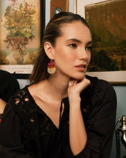 Woman with long hair wears beaded Santa Fe Earrings with a black outfit. 