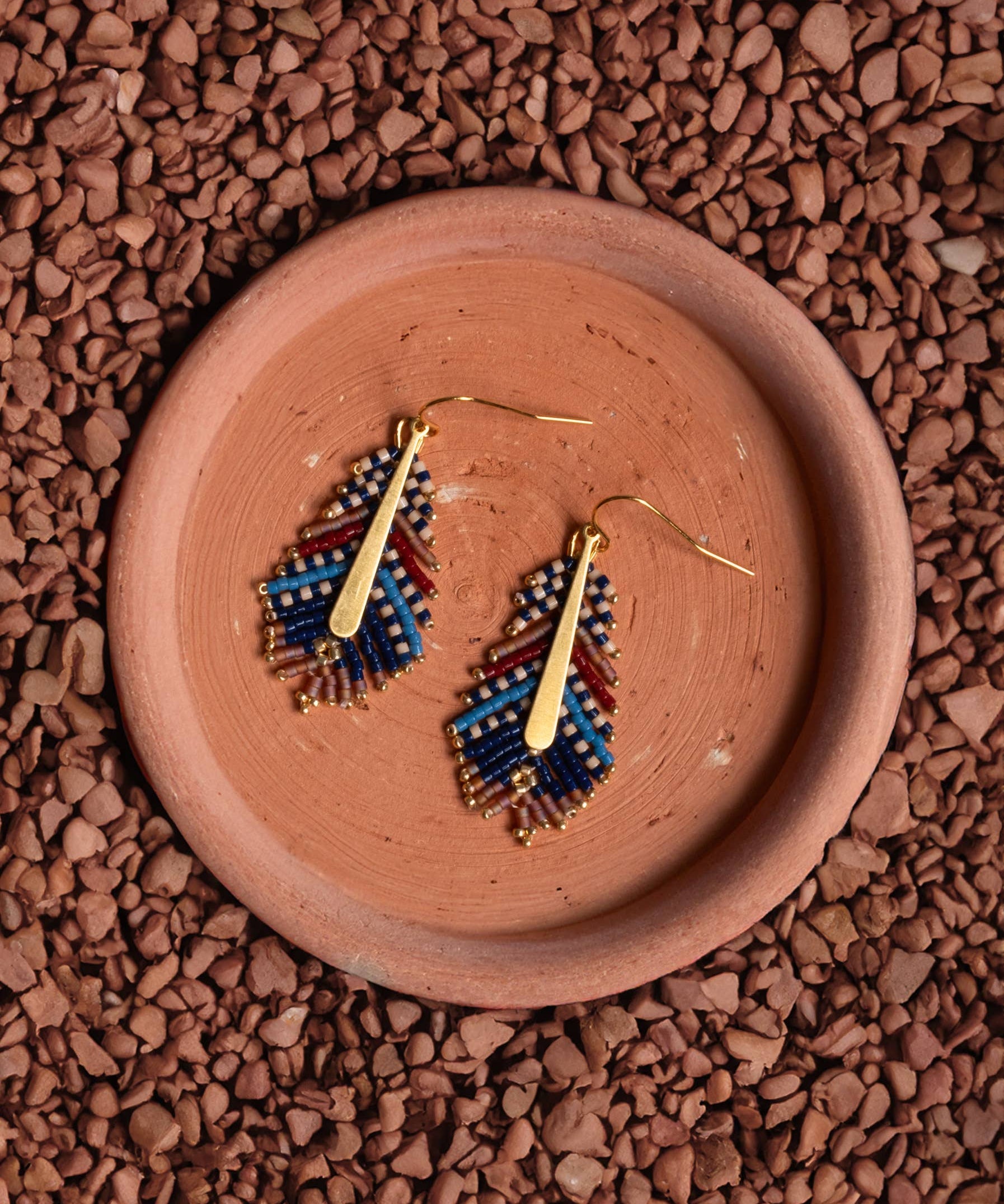 Ethically handcrafted blue and brown Miyuki beaded earrings in a delicate feather design by Mayana Designs