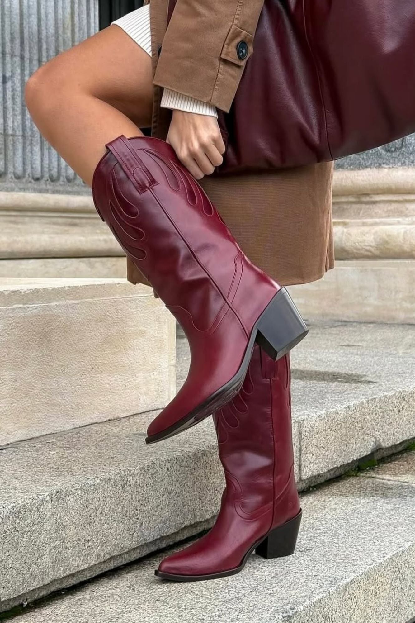 MICUIR Mestizo burgundy mid-calf cowboy boots worn on stone steps