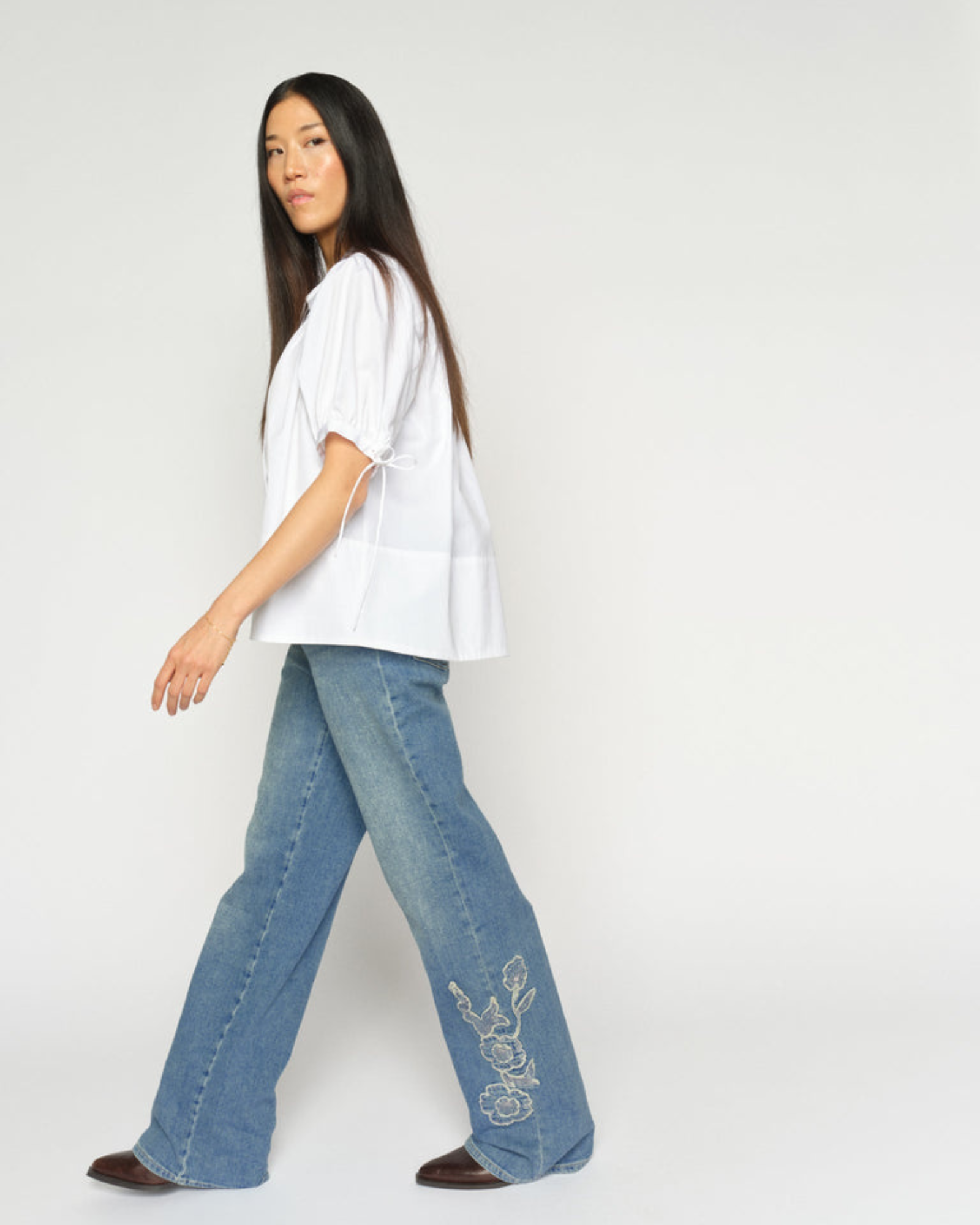 White MMTarima cotton blouse side view on model, paired with denim jeans