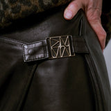 MOS MOSH Vela leather wrap skirt in black, close-up of the a sculpted metal buckle