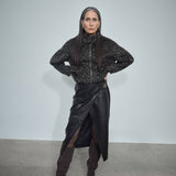 MOS MOSH Vela leather wrap skirt in black with a sculpted metal buckle, worn by a model, front view