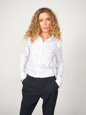 Woman wearing the slim-fit white MMTilda shirt and dark pants for  a polished office look, 