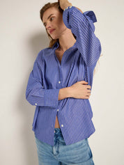 Woman wears stunning blue pinstripe shirty by Lanius for her work.