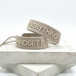 Close-up of adjustable woven statement bracelet with embroidered “MINDSET IS EVERYTHING” lettering and sliding knot tassel cords.