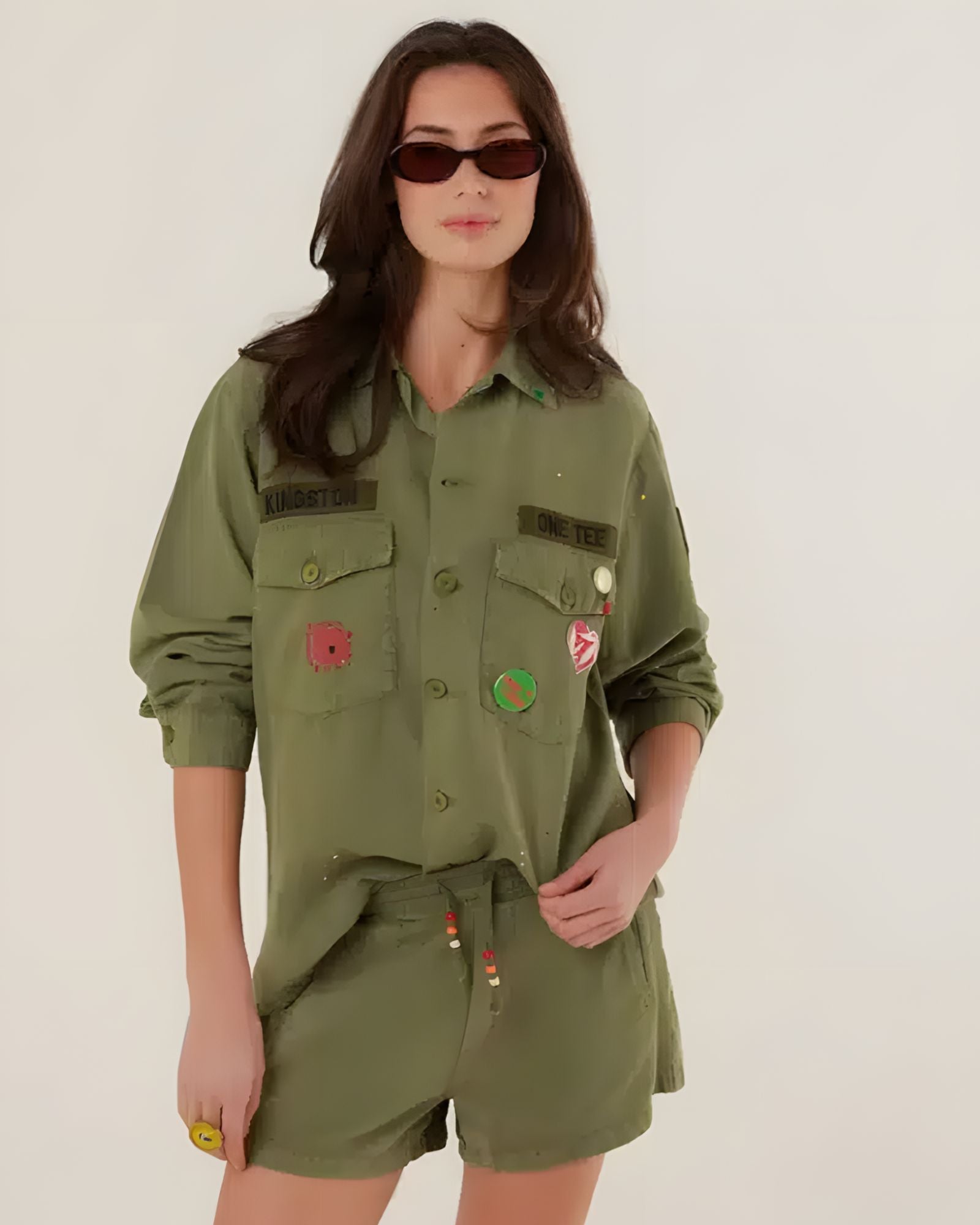 A woman wearing the high-waisted khaki Paul relaxed fit shorts, highlighting the wide-leg cut, side pockets, and bohemian beaded drawstring details.