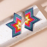 Handcrafted half-star earrings in red and emerald beads, showcasing the beautiful mix of colors and details in a bold design.