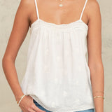 Cropped front view of a white embroidered cotton cami top by Mabe Apparel with delicate straps.