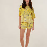 Full-length front view of a model wearing the oversized yellow bandana print Henry T-shirt featuring a mineral dye gradient, paired with matching shorts.