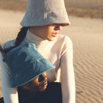 Woman wearing the Van Palma PACO bucket hat in stone on the beach