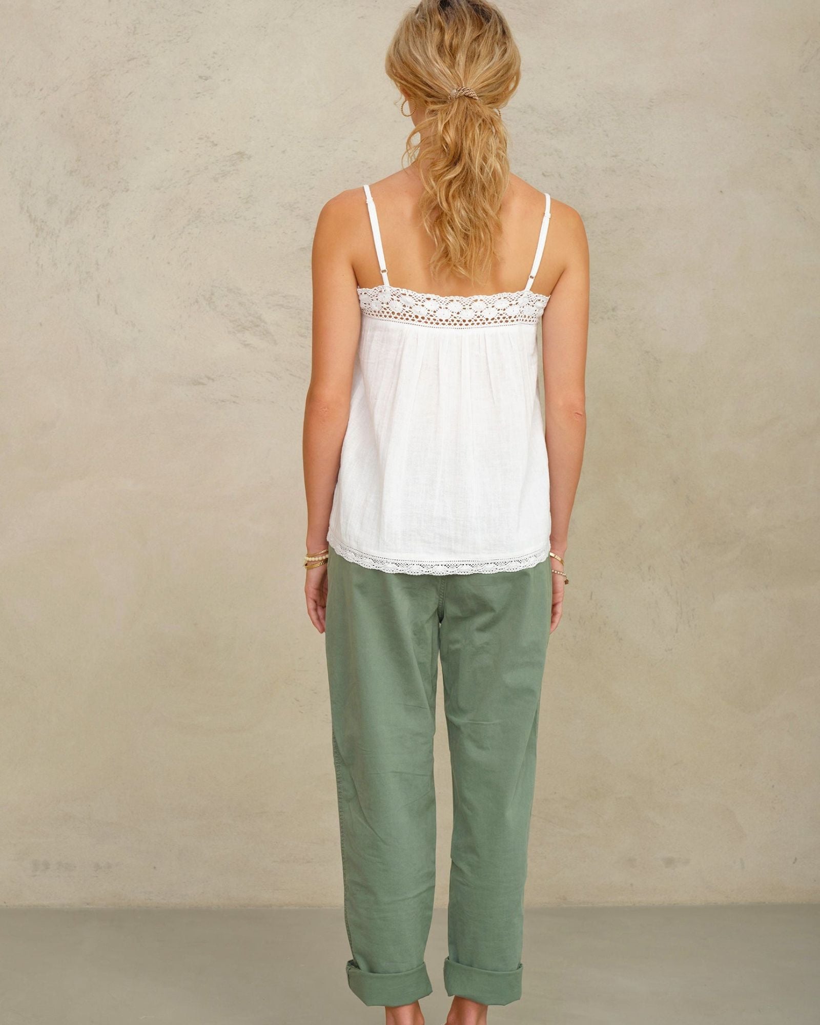 Full-length rear view of a model showcasing the straight back design and lace trim of a white camisole.