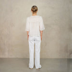 Back view of model wearing white lace cotton blouse by Mabe Apparel.