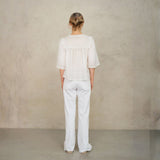 Back view of model wearing white lace cotton blouse by Mabe Apparel.
