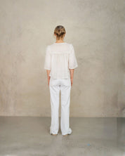Back view of model wearing white lace cotton blouse by Mabe Apparel.