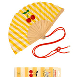 An opened summer folding fan with a yellow and white striped pattern and a bold cherry fruit print, displayed alongside its red shoulder strap and matching packaging.