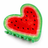 Playful heart-shaped hair claw clip designed like a watermelon slice with a glossy red center, black seeds, and a vibrant green rind against a white background