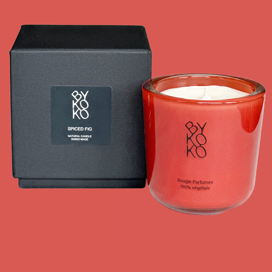 'Spiced Fig' Candle, featuring fresh fig leaf notes complemented by a tantalizing blend of pink pepper and cinnamon. Presented in a striking red glass container.
