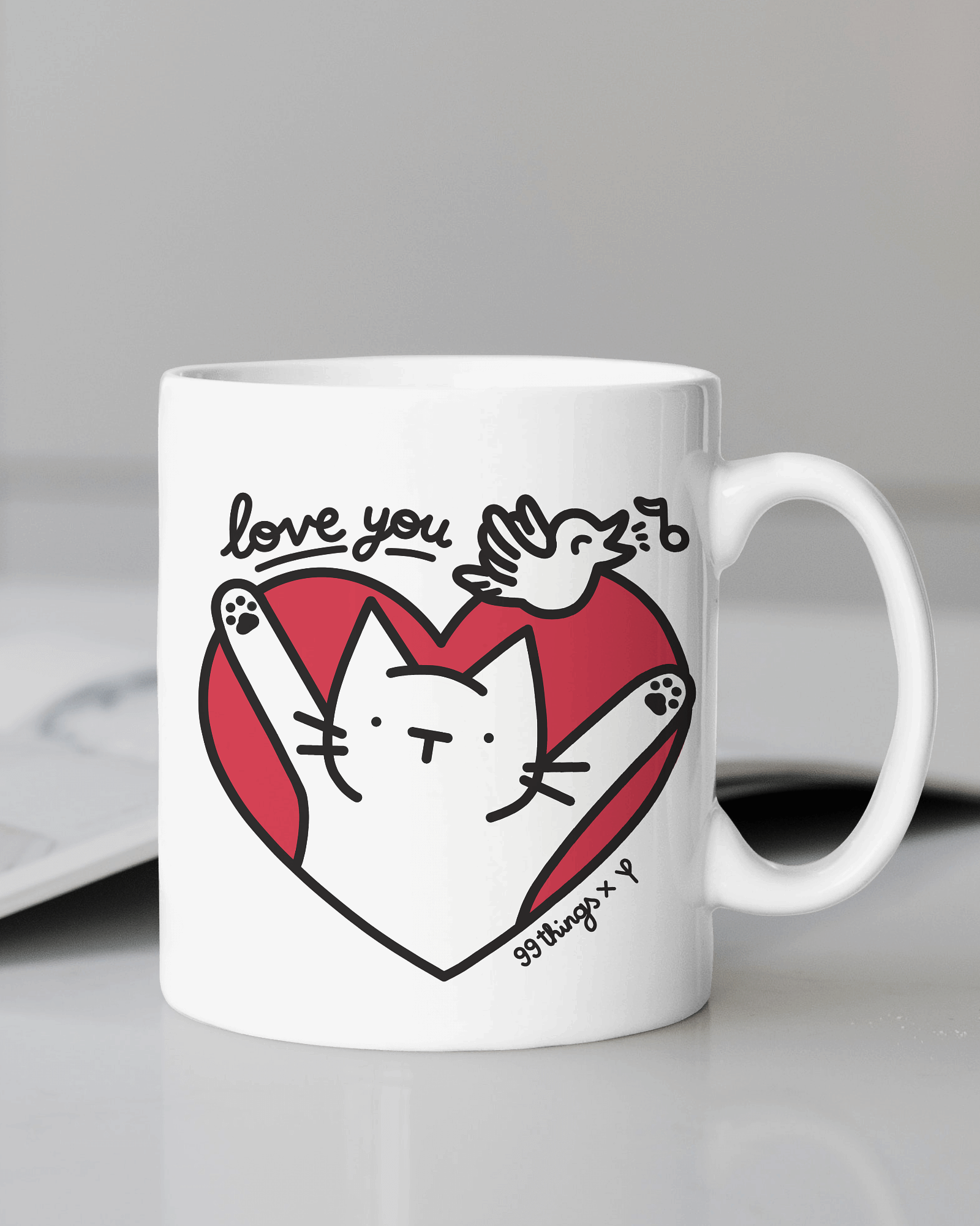 a white coffee mug with a happy cat and red heart