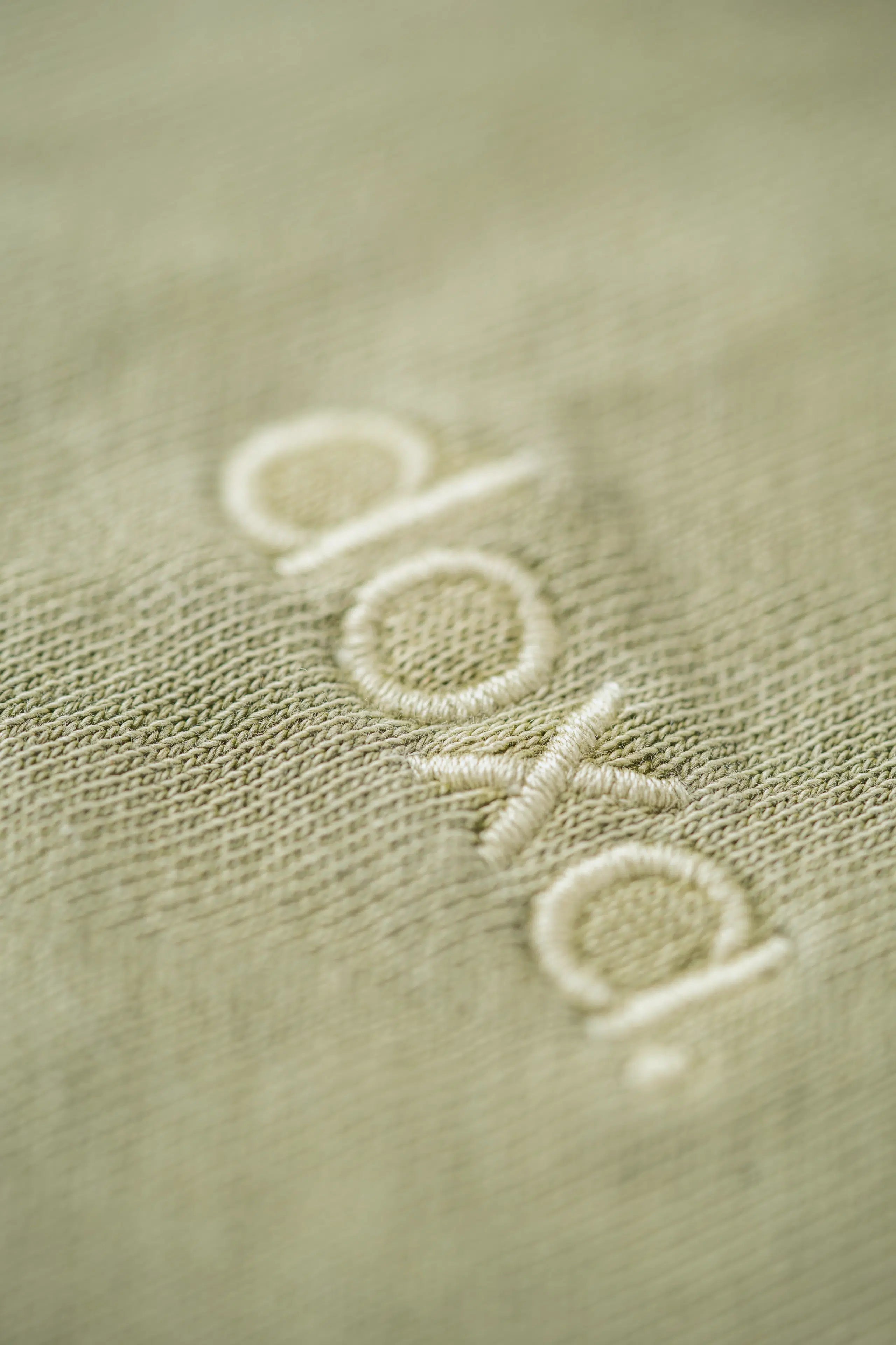 Sustainable Fashion Brand's DOXA embroidered logo and close up of the organic, mineral dyed fabric used for their Men's Hoodies