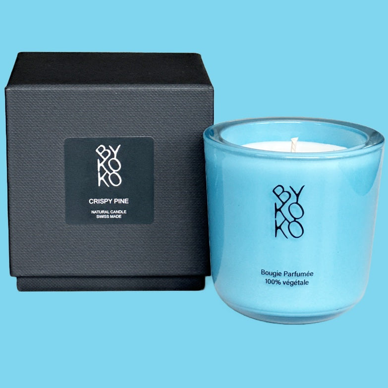 Crispy Pine candle, evoking the freshness of frosted pine needles and the tranquility of a snowy forest. Handmade in Switzerland in light blue glass container.