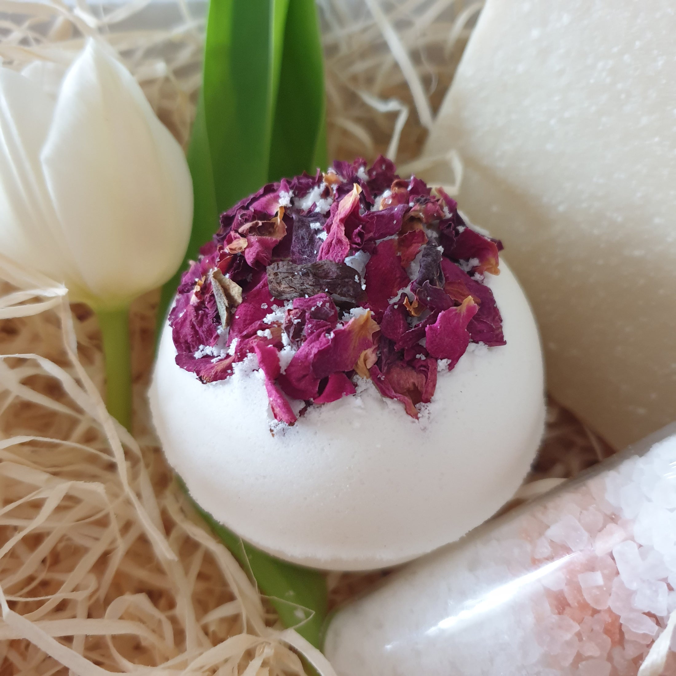 Handmade vegan rose bath bomb, showcasing its natural ingredients like dried rose petals.
