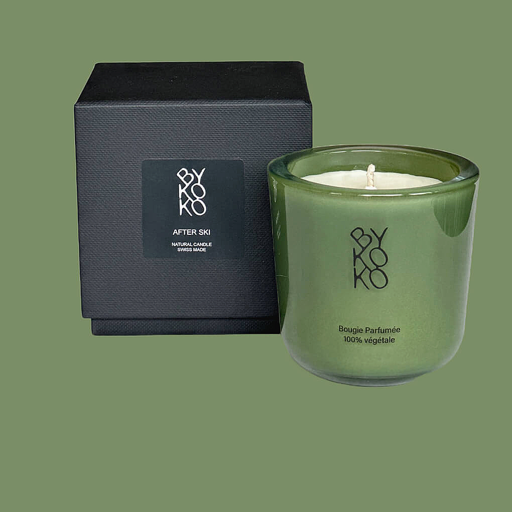 AFTER SKI candle, blending amber and vanilla for a cozy winter retreat. Sparkling citrus, tuberose, and musky base notes evoke après-ski comfort. Presented in a green glass container.