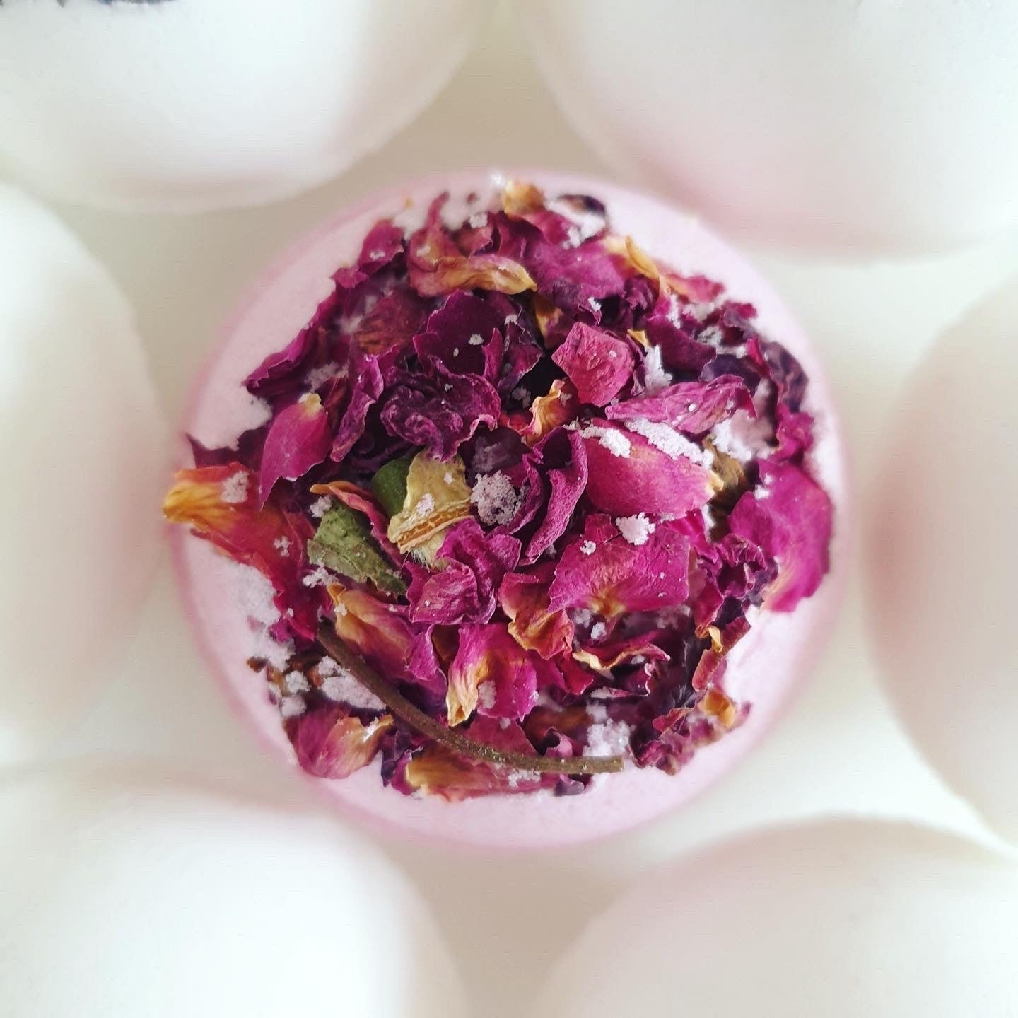 Anti-Anxiety Secret Bath Bomb with vibrant pink colour thanks to beetroot powder. Scented with bergamot, lavender, ylang-ylang essential oils, decorated with dried rose petals.