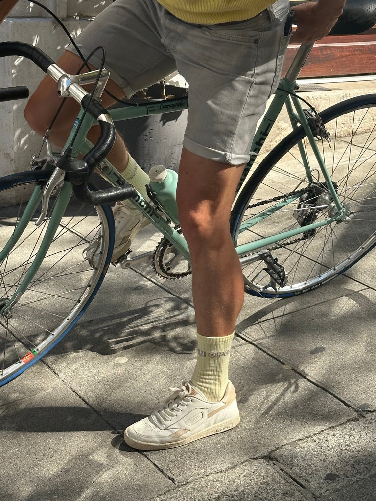 a man riding a bike wearing yellow ribbed socks by Chaton Gonflable