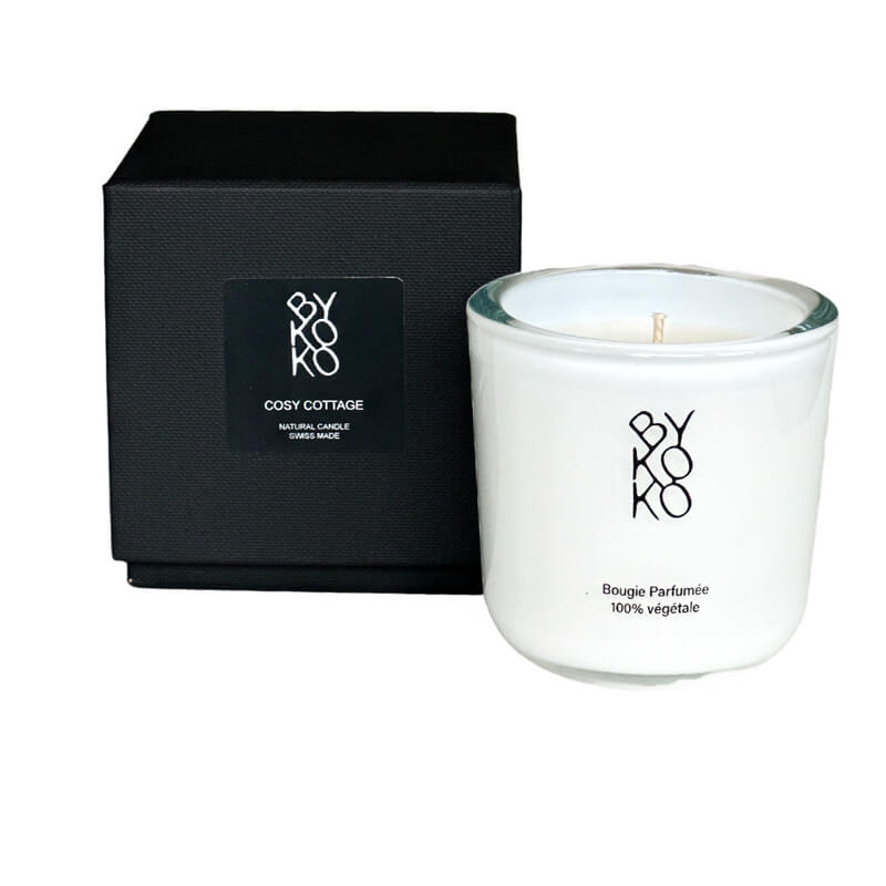 Cozy Cottage candle in a white sustainable glass container, blending the delicate scent of pear blossom with sandalwood and musk.