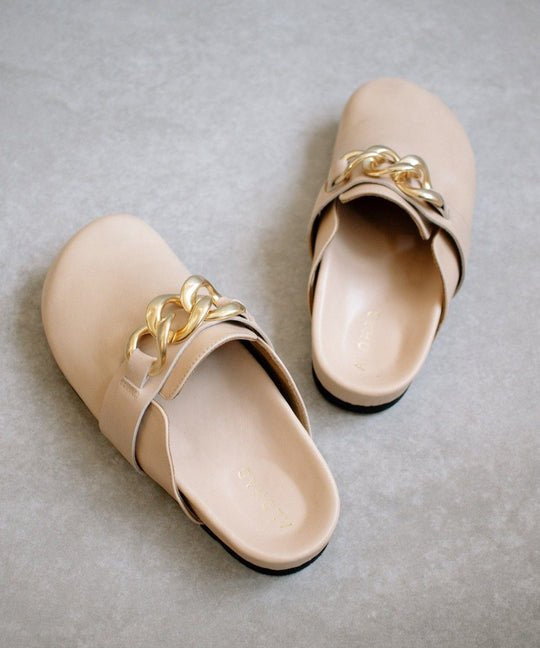 ALOHAS nude leather clogs shown as a pair, with gold chain-link trim across the front strap.