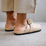 Back view of the ALOHAS nude clogs worn on the feet, showing the low block heel and open back.