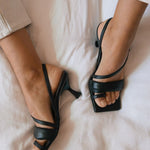 Woman wearing the ALOHAS black square-toe slingback heels.