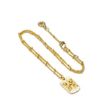 Azuni Astral ID Tag necklace shown with its gold beaded chain coiled on a white background.