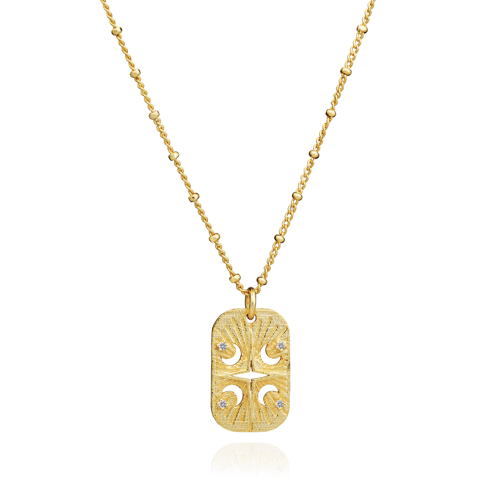 Azuni Astral ID Tag necklace, a gold rectangular tag engraved with a moon and stars on a beaded chain.