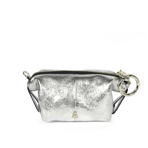 Craie Studio Doux wallet in silver metallic leather with D-rings and a zip closure, on a plinth.