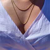 Crystal Haze gold-plated box chain necklace worn with a white top, outdoor lifestyle shot