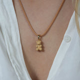 Crystal Haze caramel Nostalgia Bear pendant worn on a matching caramel cord necklace.