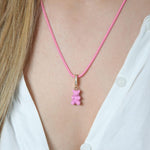 Crystal Haze candy pink Nostalgia Bear pendant worn on a pink cord necklace, resting at the collarbone.