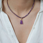 Crystal Haze purple Nostalgia Bear pendant worn on a necklace, resting at the collarbone.