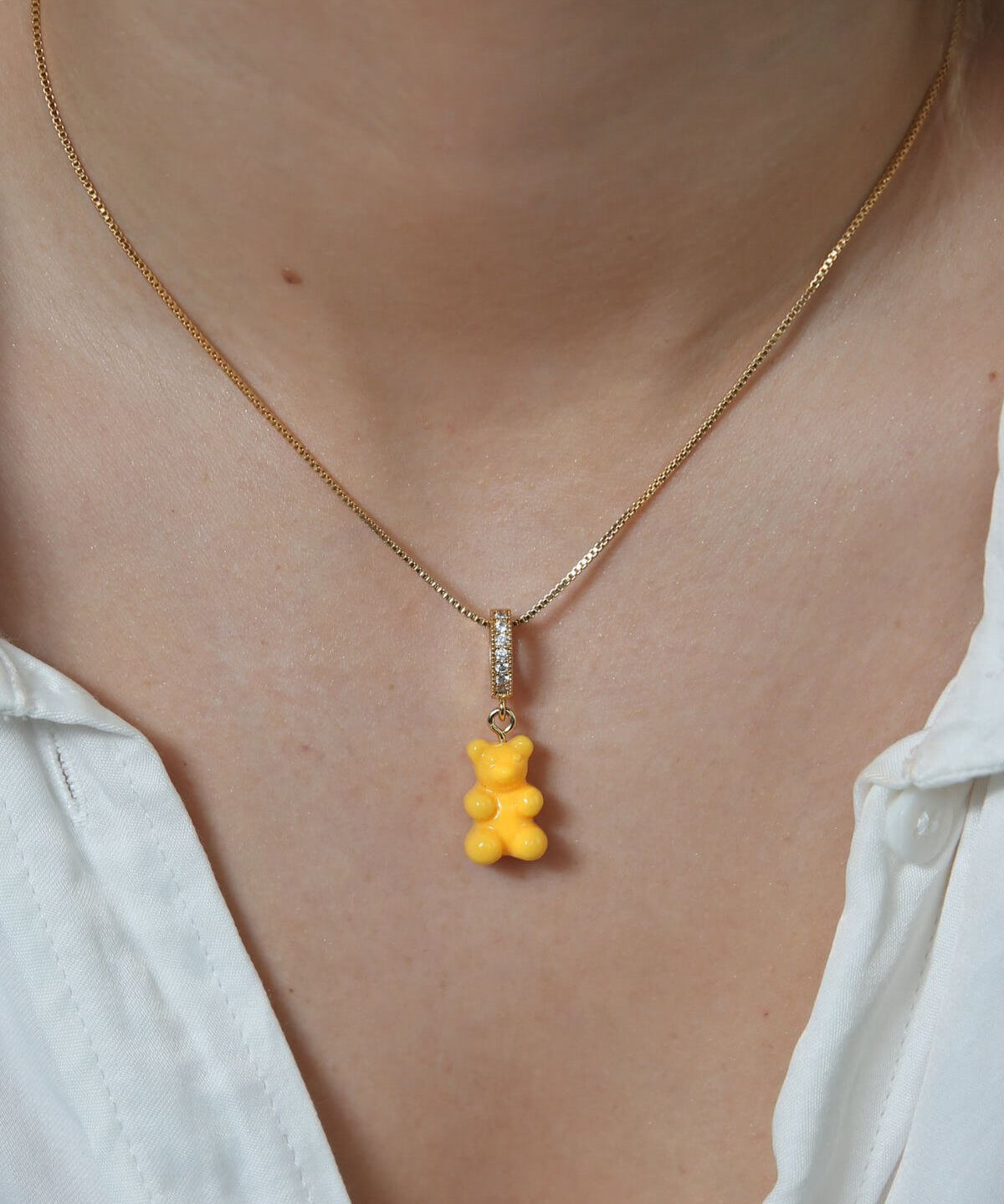Crystal Haze yellow Nostalgia Bear pendant worn on a fine gold chain necklace