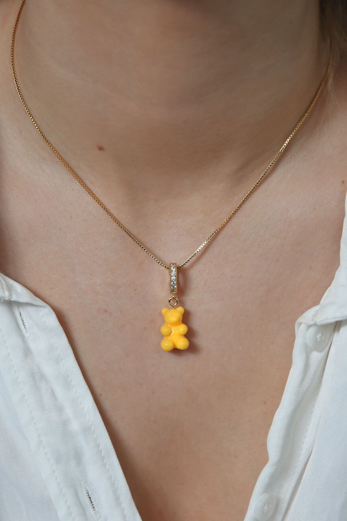 Crystal Haze yellow Nostalgia Bear pendant worn on a fine gold chain necklace