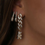 Close-up of the Crystal Haze Pavé Nostalgia gold earring worn on the ear, showing the pavé chain and bear charm.