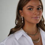 Model wearing the Crystal Haze Pavé Nostalgia gold earring layered with hoops and a chain necklace.