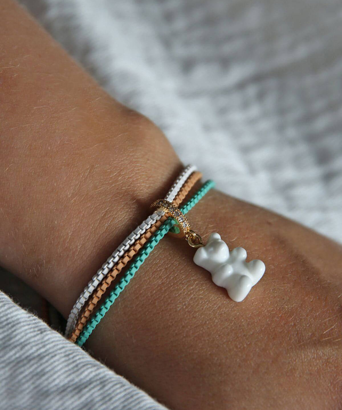 Crystal Haze Plastalina bracelets worn stacked on the wrist with a white Nostalgia Bear charm.