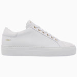 Nubikk Jolie minimalist white leather sneaker with gold eyelets, side profile on a white background.