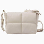 NUBIKK beige May leather bag, side profile flat lay showing the NBKK logo tab