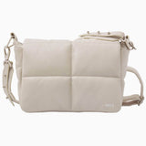 NUBIKK beige May leather bag, side profile flat lay showing the NBKK logo tab